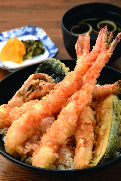 A satisfying prawn tempura bowl topped with four prawns and other tempura such as lotus root and eggplant is priced at 1,300 yen and includes a soup.