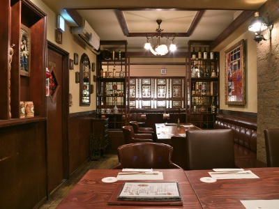 The restaurant has a mature atmosphere with stately-looking desks and chairs and sparkling stained glass windows.